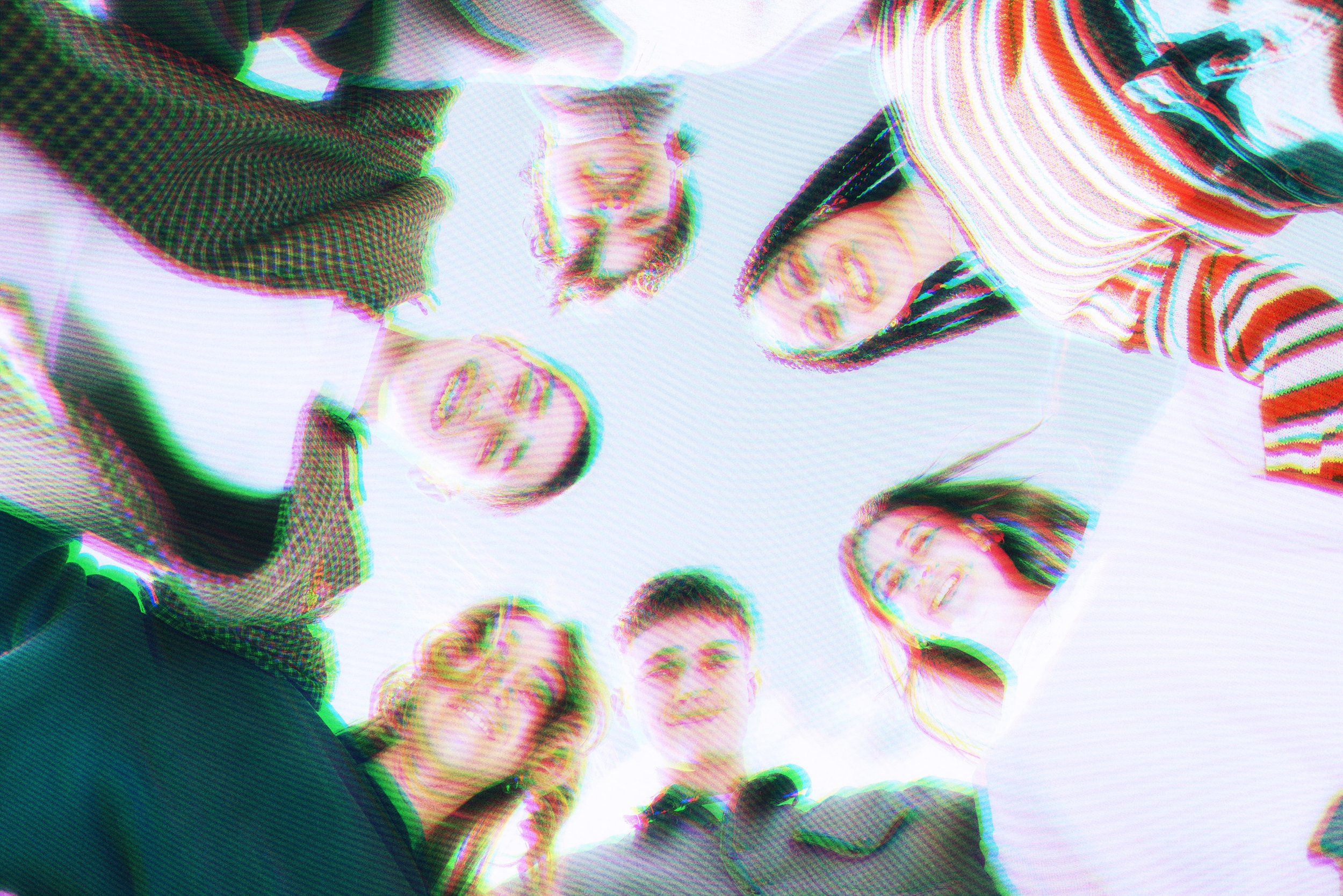 A group of six people looking down at the camera, with a distorted, glitch effect on the image.