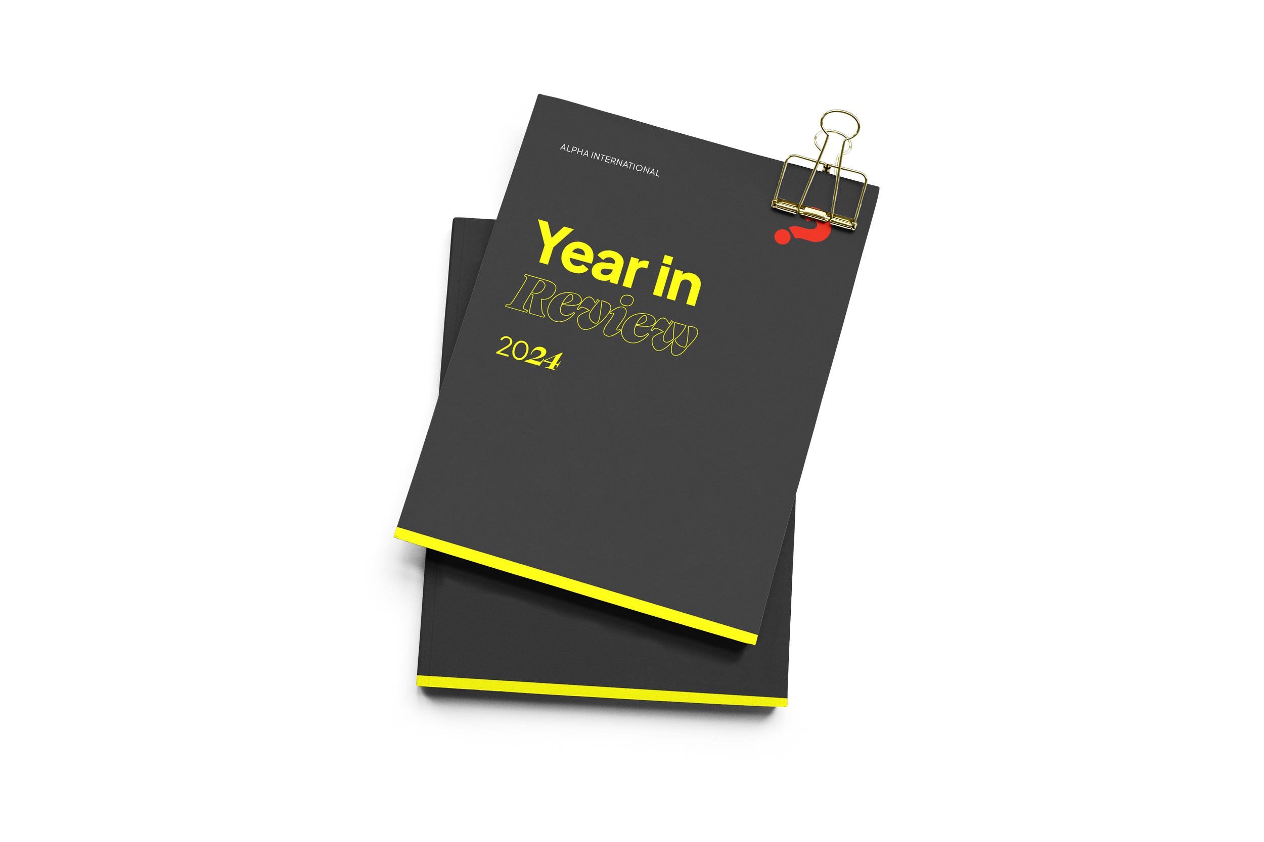 A black planner titled 'Year in Review 2024' clamped with a gold paper clip. Text is in yellow and outlined in black, with small red accents, on a black background.